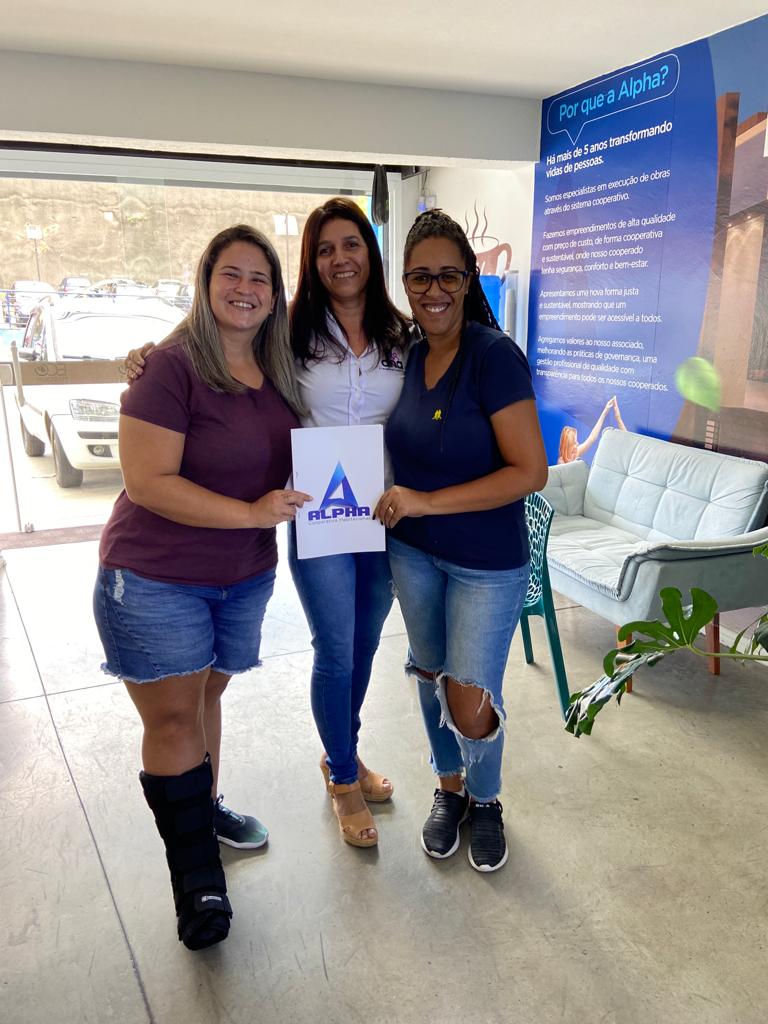 Cooperada 4 e sua mulher segurando o plano da Alpha Cooperativa com a corretora Silmara